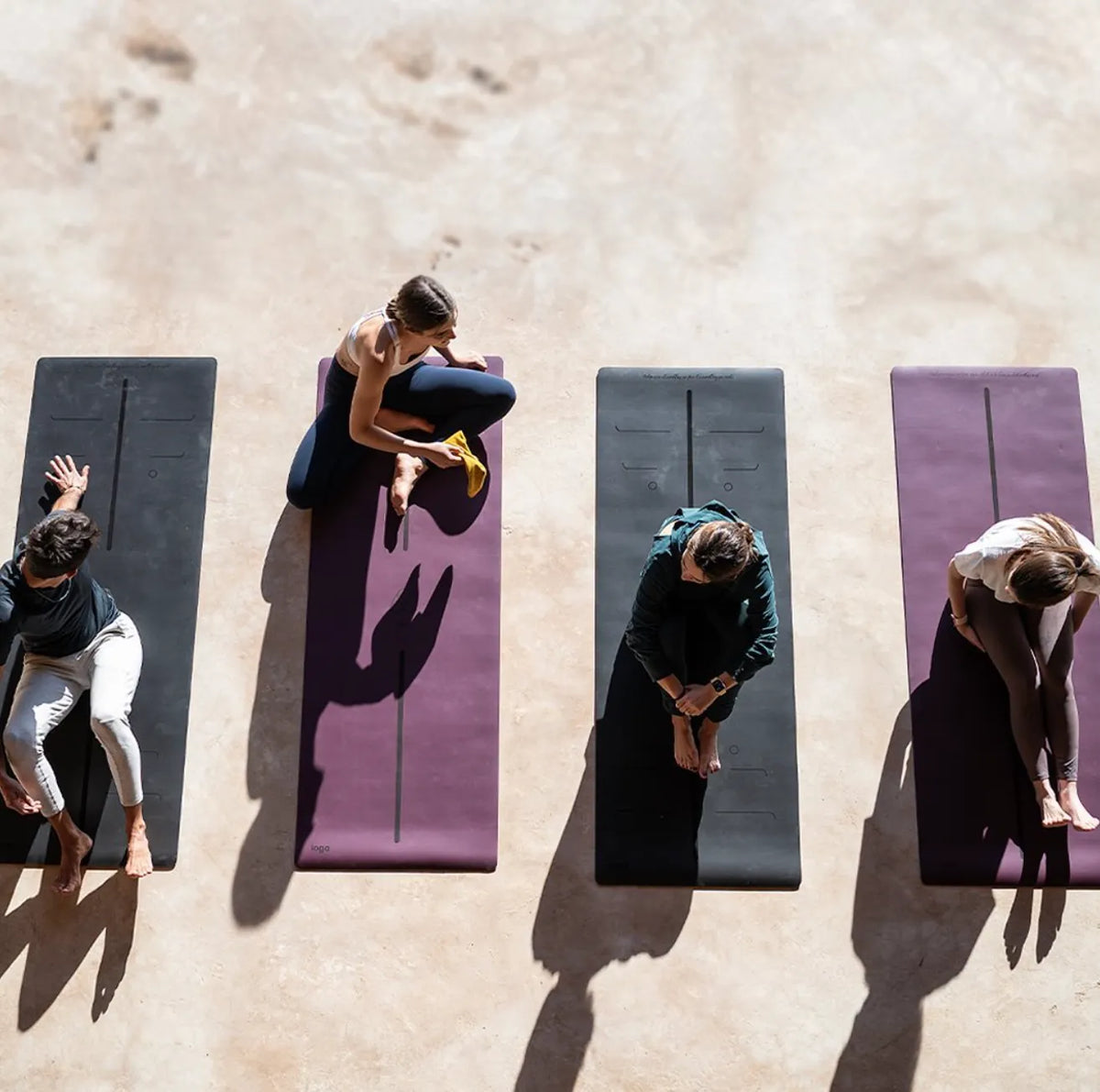 Clase de yoga vista desde arriba con tapetes ioga, entre ellos el Serenity Mat color vino