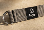 Detalle macro del label tejido ioga, las anillas D plateadas y la cincha gris carbón