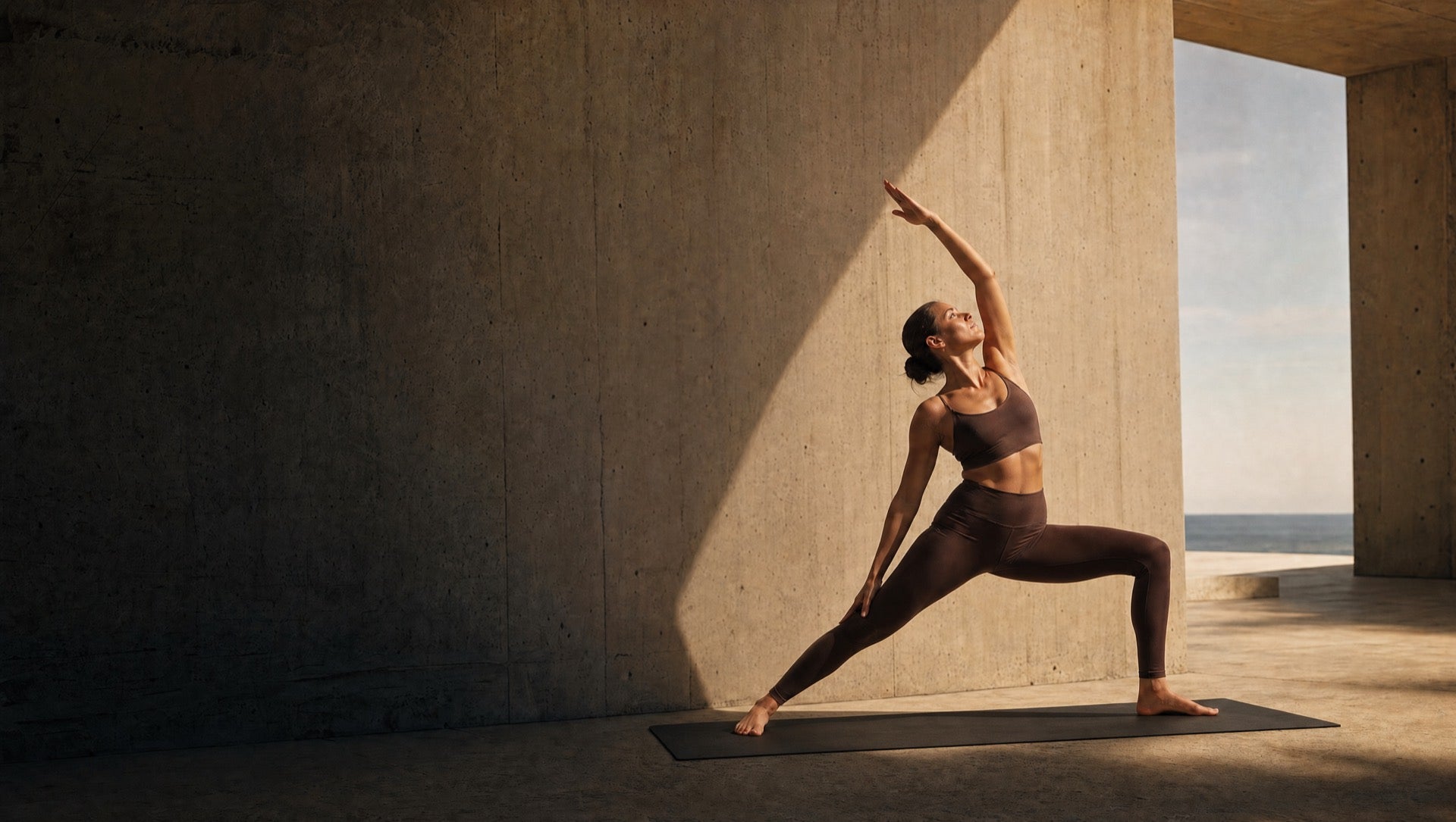 Mujer en práctica de yoga en arquitectura mexicana frente al mar