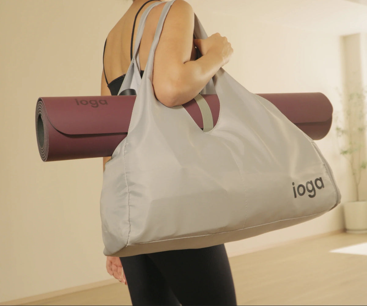 Tapete de yoga ioga enrollado dentro de una bolsa de tela, listo para viajar