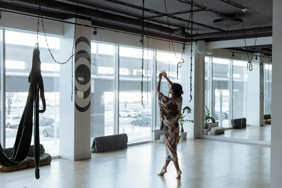 Practicante de yoga avanzado en un estudio profesional con telas aéreas